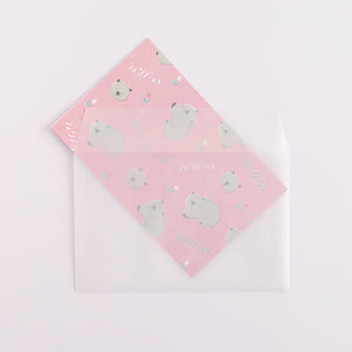 Folded paper with wombat illustrations sliding inside envelope