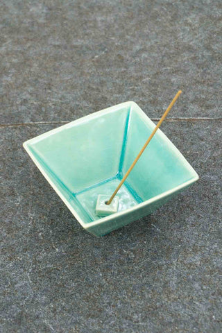 Green glazed incense burner bowl with incense stick and inner well