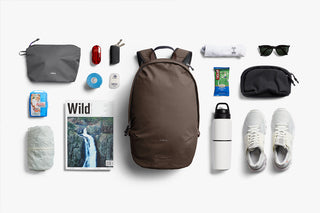 Collection of travel items including a backpack, shoes, and toiletries on a white background