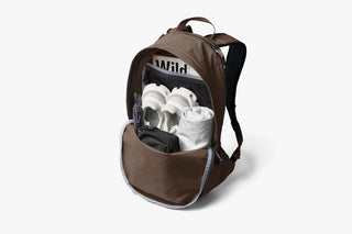 Brown backpack with white items inside on a light gray background