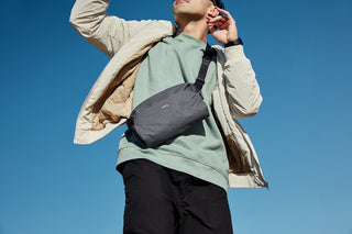 Person with bag for size comparison on light blue background