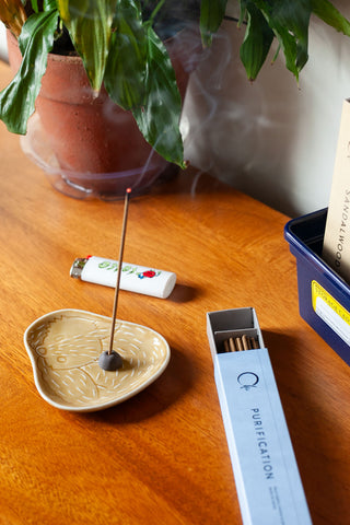 Chie incense burns on a cut fox plate on a wood table