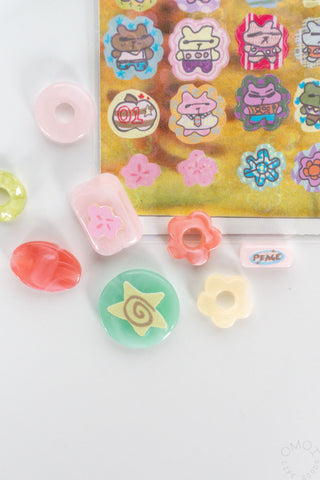 Close up of colorful bear sticker sheet with beads on a white background