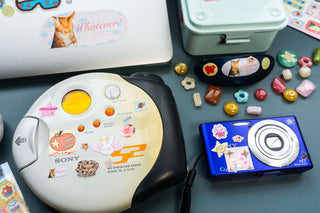 Vintage CD player and blue camera with stickers on a blue background