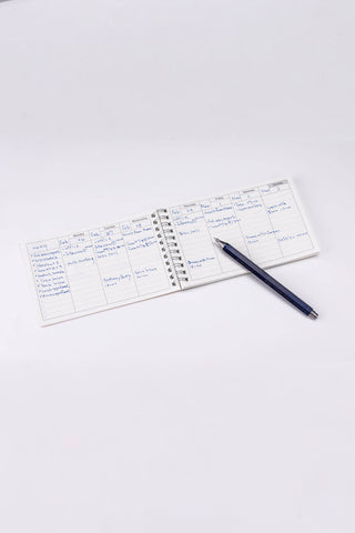 Weekly schedule opened with pen and writing on a white background