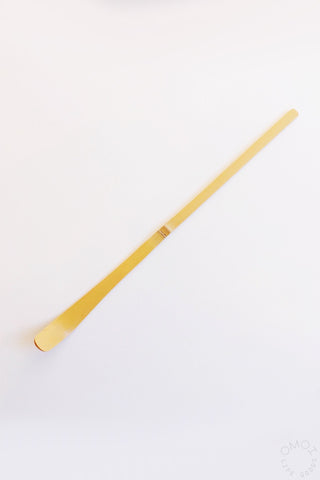 Wooden matcha chashaku scoop on a white background