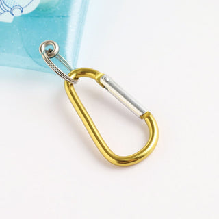 Gold-toned metal keyring with clear strap rings on a light blue alien mini case