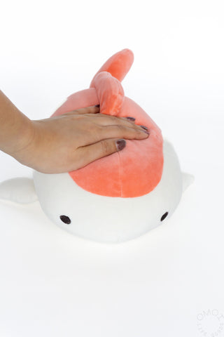 Hand on top of Goldfish plush on a white background