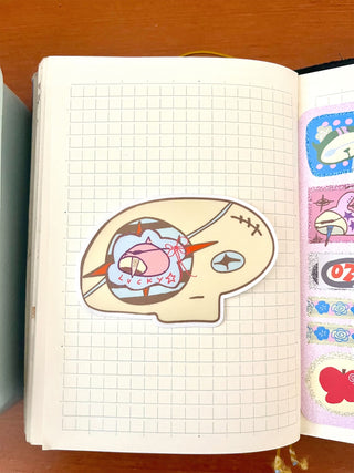 Colorful skull head sticker on a grid notebook