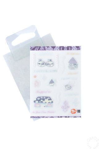 White, blue, and purple sticker sheet outside of card sleeve packaging on a white background