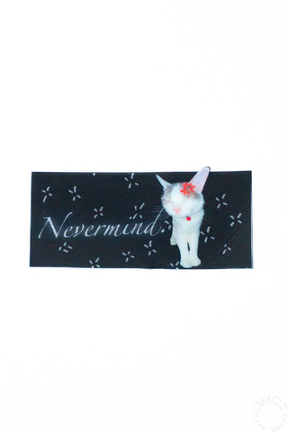 Black rectangle cat sticker with Nevermind text on a white background
