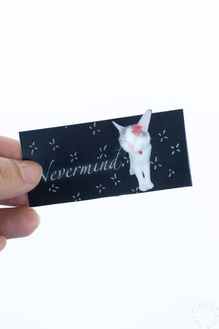 Hand holding a black rectangle sticker with cat on a white background