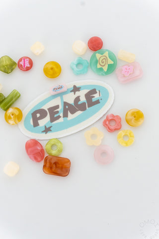 Blue peace sticker on a white background with colorful beads