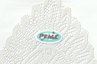 Blue peace sticker on a white lace background