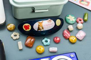 Colorful beads with a dark blue hair clip decorated with stickers on a blue background
