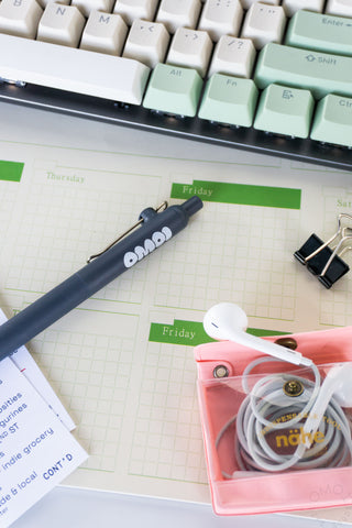 Keyboard, Zento pen, earbuds, and planner on a desk