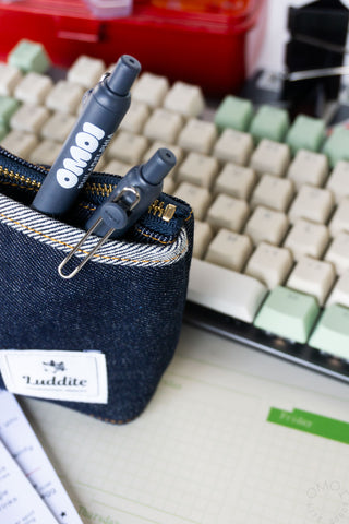 Blue denim zipper pouch with two Zento  pens on a keyboard