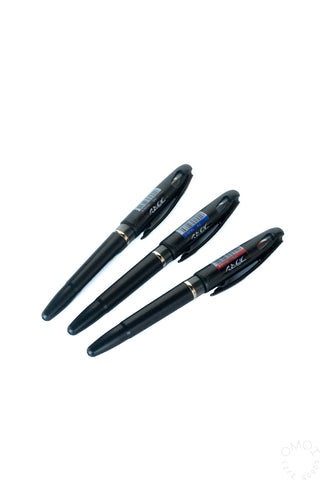 Three ink markers in black, blue, and red with pointed tips.