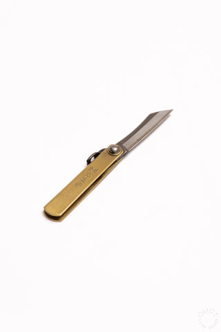 Mini pocket knife with brass handle, blade extended slightly, lanyard loop