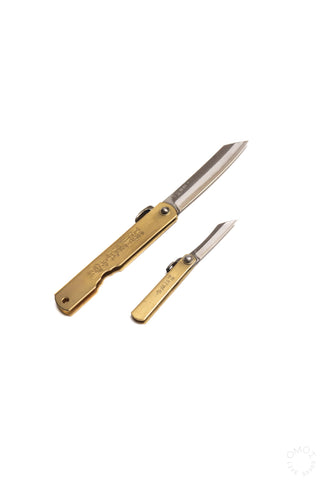 Mini pocket knife set with brass handles, one blade open and one folded