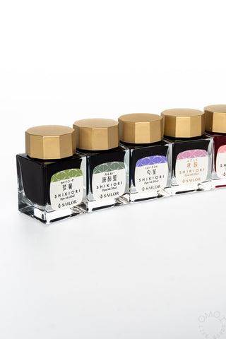 Set of Shikiori ink bottles with gold caps on a white background