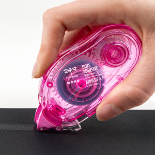 Pink adhesive tape dispenser held by a hand on a white background