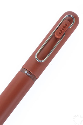 Brick red gel pen close-up with chrome clip and small color label