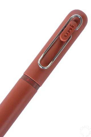 Brick red gel pen close-up of chrome clip and grip area