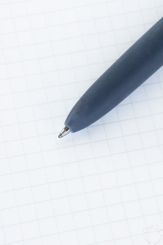 Close-up of OMOI blue-grey Zento pen tip on a white grid background