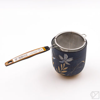 Floral fine mesh tea strainer with wooden handle and blue patterned cup
