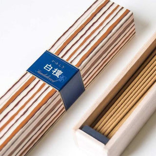 Sandalwood incense sticks in striped sleeve with blue label, plus loose incense tray