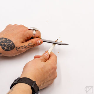 Pocket knife with satin blade and black handle, shown in hand