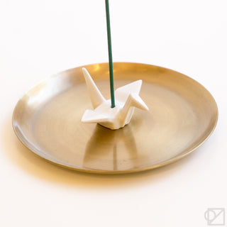 White origami crane incense burner with round tray and green incense stick