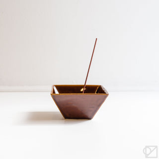 Brown square incense burner bowl with incense stick inserted