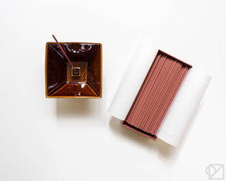 Glossy brown square incense burner with incense sticks nearby