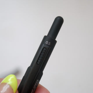 Matte black multi-pen close-up with 0.5 marking and control window