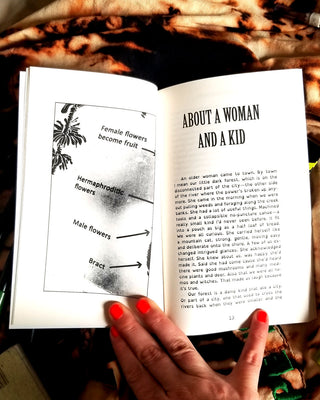 Open book pages with diagrams and article text, held by a hand