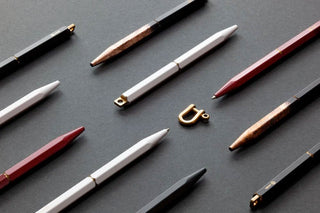 Multiple ystudio brass pens on a grey background